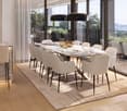 Dining room with large table, white chairs, marble table top, large windows, balcony, plants, lamps