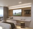 modern bedroom with bed, desk, TV, rug, and a view of the mountains