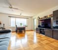 Couches, TV, desk, table, chair, guitar, books, clock, window