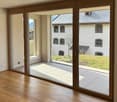 Floor room with wooden floor and glass sliding doors to terrace with a grassy area outside