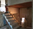 Stone and brick wall, concrete steps, blue paint, ladder, workman, tools, and construction materials
