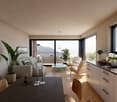 Spacious living room with large windows offering a scenic view of the mountains and lake. The room features a comfortable sofa, armchair, and a wooden dining table. There are also various decorative elements such as plants, vases, and a TV mounted on the