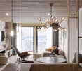 Open layout living room with large windows, couch, armchair, desk, round table, lamps, chandelier, rug, coffee table, coffee cup, wine glasses, view