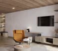 Spacious living room with wooden ceiling, gray walls, wooden shelving unit, leather armchair, coffee table, and a mounted TV on the wall