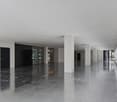 modern office space, large entrance, white walls, tiled floor, large windows, white columns