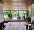 Wooden floor, wooden ceiling, brick fireplace, large windows, sliding glass doors to the terrace