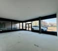 empty room, white walls, white tiles, large windows, glass doors, chairs, trash bin