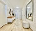 Long corridor with white walls, wooden floor, large mirror, wooden counter, and modern style