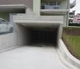 Underground garage with a vehicle parking underneath a raised ground floor of an apartment building
