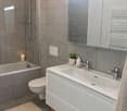 modern bathroom with shower enclosure, bathtub, toilet, sink, and mirror