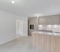 modern kitchen with white walls, wooden countertops, built-in oven, dishwasher, and washing machine