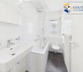 white tiles, white sink, bathtub, toilet, radiator, window