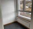 empty room, black tile floor, white wall, large window with a view of the outside