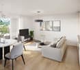 modern living room with white walls, wooden floor, round dining table, white couch, TV, plants, and artwork