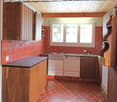 Wooden cabinets, tiled counter, tiled floor, tiled backsplash, dishwasher, fridge, stove, windows