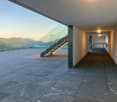 Concrete floor, glass wall, wooden deck, staircase with glass railing, outdoor ping pong table, mountain view
