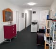empty room, white walls, red cabinet, printer, couch, shelves, banner