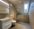white sink, white toilet, white cabinetry, white tiles, window, walk-in shower