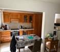 equipped kitchen, dining area with table and chairs, wooden cabinet