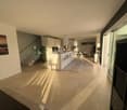 open plan living and dining area, modern kitchen, large windows, beige tiles, staircase, glass railings