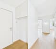 Empty room, white walls, wooden floors, ceiling light, cabinets