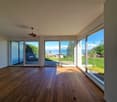 large room, hardwood floors, sliding glass doors, balcony, view of the lake and mountains