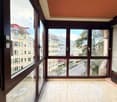 Large windows, wooden floor, panoramic view, reflection of city outside