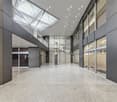 modern building, large entrance hall, glass walls, white ceiling, gray walls, large windows, skylight