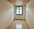 Empty room, wooden ceiling, radiator, wooden floor, window