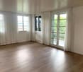 empty room, wooden floor, white walls, white curtains, windows, balcony with railings