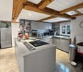 modern kitchen with island, wooden beams, granite floor, stainless steel appliances, dishwasher