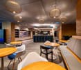 modern interior, wooden tables, white chairs, gray bench, wooden wall panels, hanging lamps, blue lighting, counter with Bistro sign
