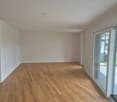 Empty room with white walls, hardwood floors, sliding glass doors leading to a balcony.