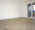 Empty room, large windows, balcony, wooden floor, white walls, power outlet
