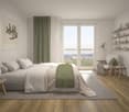 Spacious bedroom with large windows, hardwood floors, white walls, gray and green color scheme, king-size bed, shelves, and a comfortable armchair.