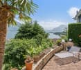 tiled patio, metal lounge chair, potted plants, hedge, mountain view, water view