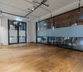 Glass walls, hardwood floors, ceiling lights, glass door, round tables, chairs