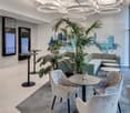 modern office reception area with round tables, chairs, plants, and a couch