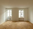 empty room, white walls, wooden parquet floor, glass doors to balcony