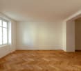 Empty room with parquet floor, white walls, and a single window