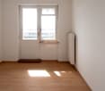 Empty room with wooden floors, white walls, glass window, white door