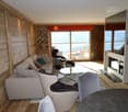wooden walls, large sofa, armchairs, fireplace, large windows, television, coffee table, desk, chairs, table