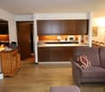living room with couch, microwave, dining table, and kitchen