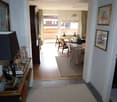 interior hallway, wooden flooring, dining table with chairs, rug, balcony, radiator, desk, shelves with books, lamp, frames, mirror