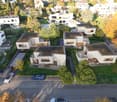 Aerial view of residential houses with solar panels, swimming pools, balconies, and parking areas