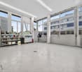 large room, concrete flooring, white walls, large windows, storage units, trolley, cleaning equipment