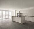 Open kitchen, balcony, sliding glass doors, gray tiled floor, white kitchen cabinets, black island countertop, modern appliances, minimalistic design