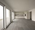 white walls, gray flooring, kitchen area with cabinets, countertops, sink, open sliding glass doors to balcony