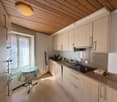 Kitchen with wooden ceiling, countertops, stove, sink, cabinets, refrigerator, table, and window