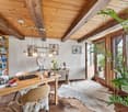 wooden beams, wooden floor, desk, chair, bookshelf, windows, plants, animal skin rug, table